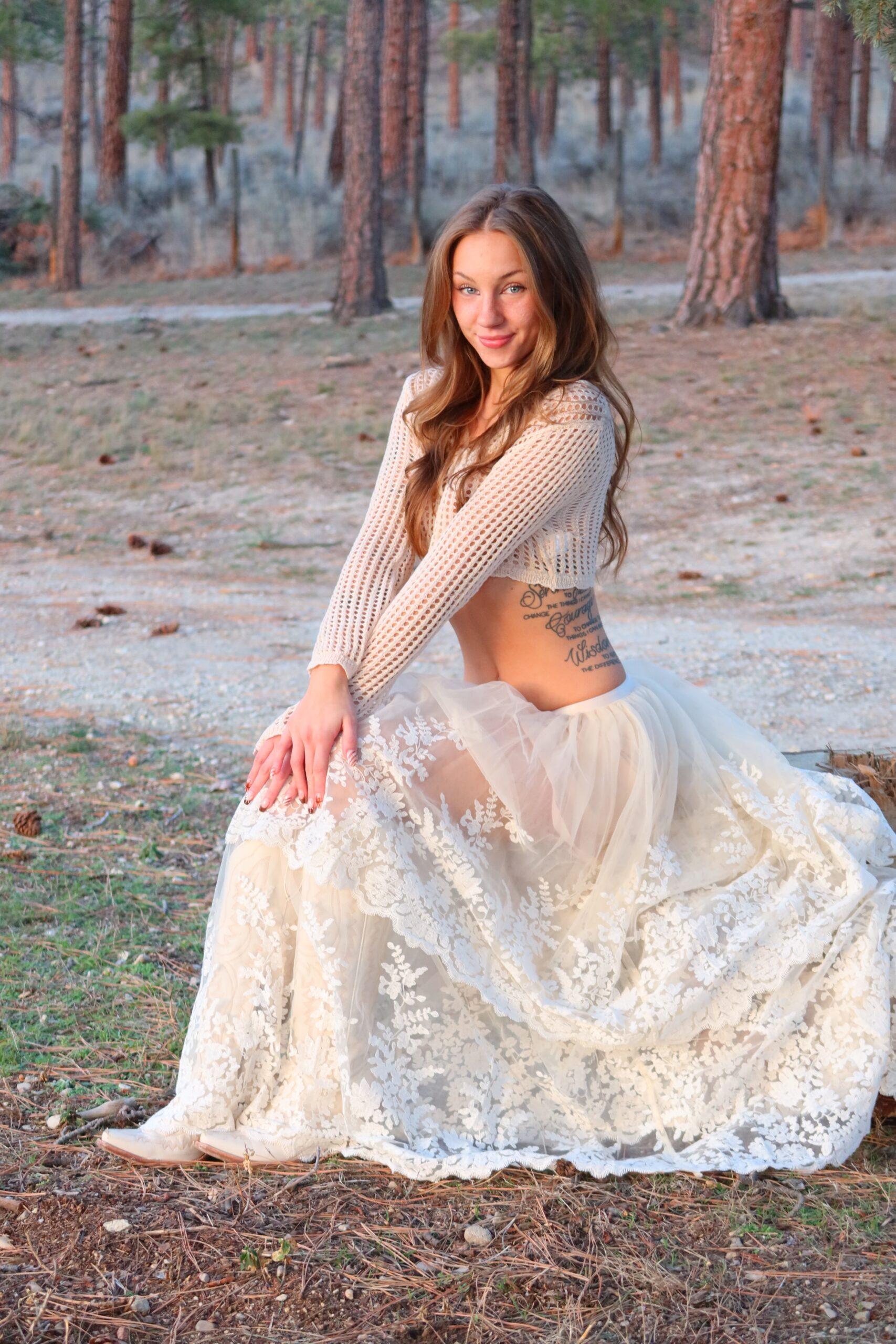 Anya Lacey smiling at the camera wearing a white skirt