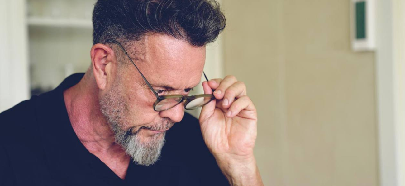 Man with glasses looking down