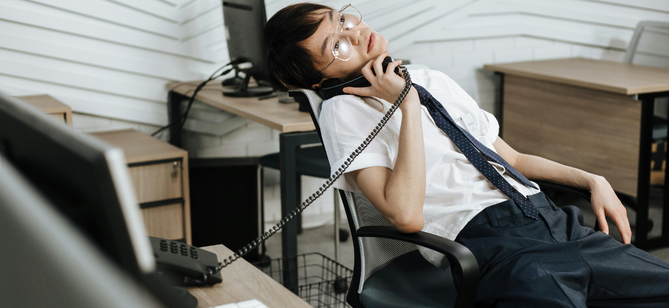 Man slumped over in chair on phone