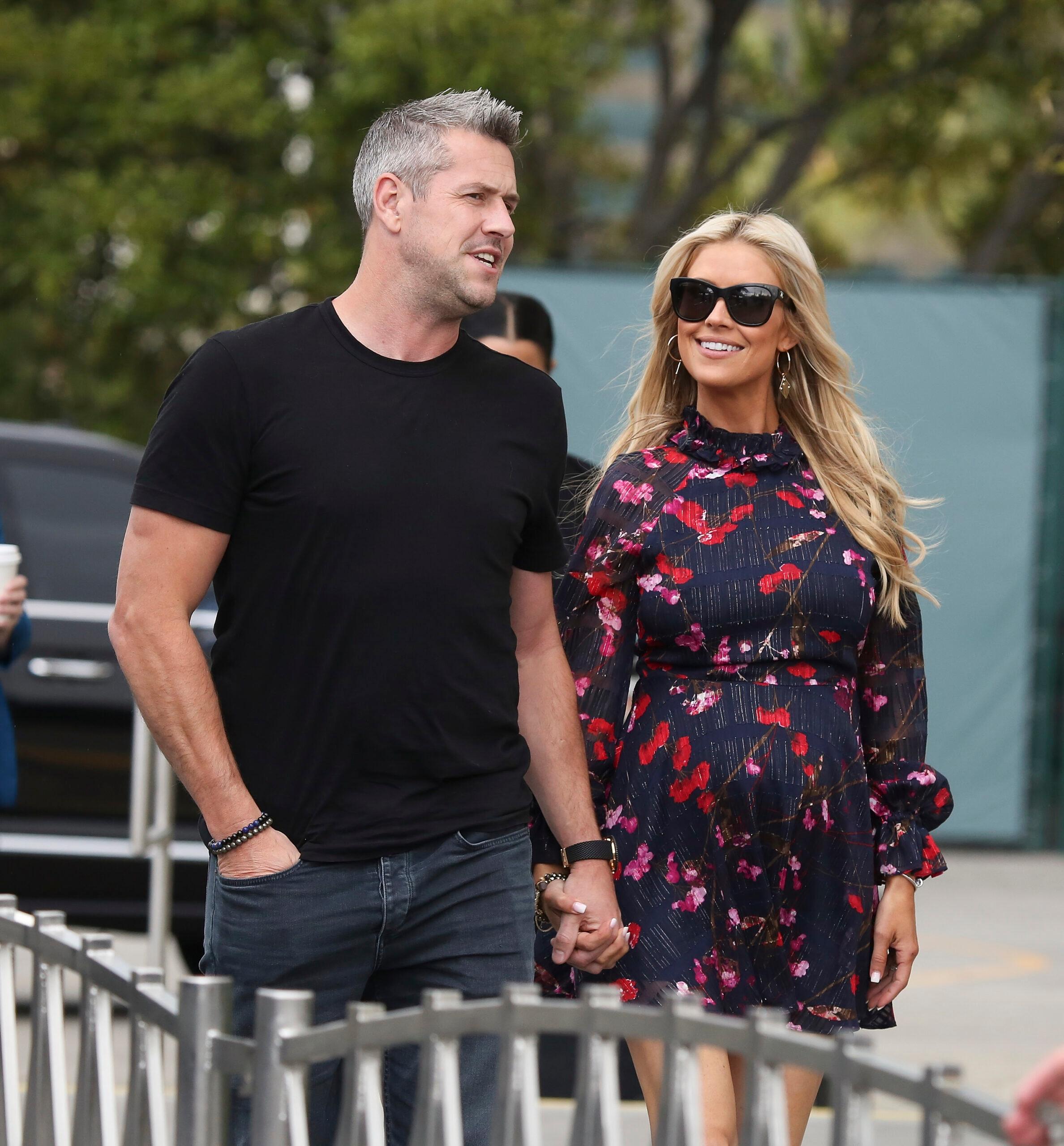 Pregnant Christina Anstead and her husband Ant holding hands 