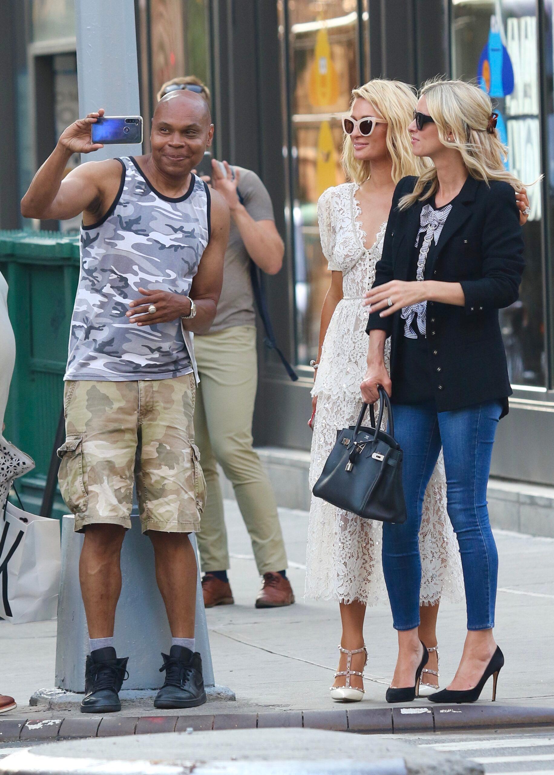 Paris and Nicky Hilton pose with fans.