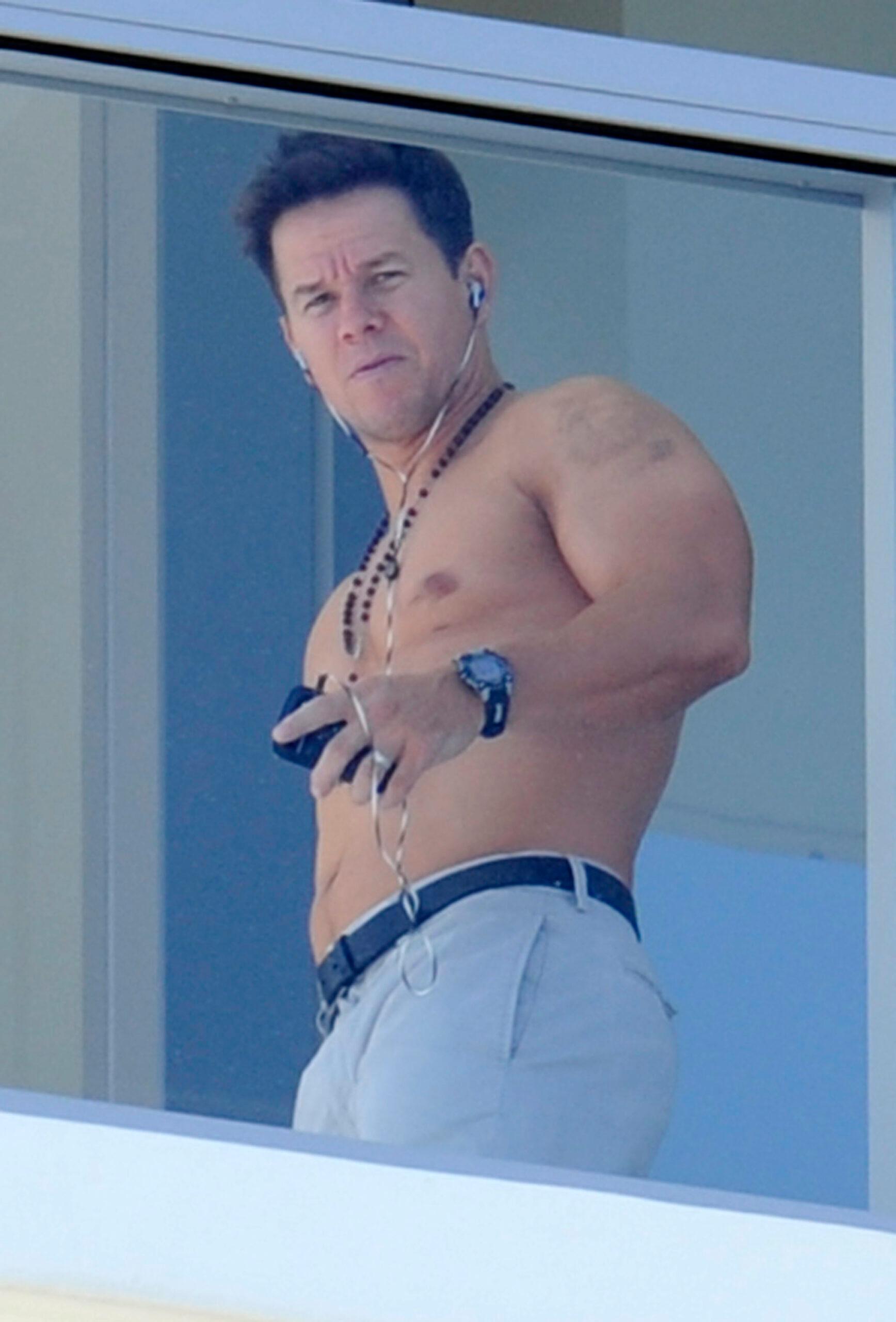 Mark Wahlberg shows off his muscles while waving shirtless from his South Beach hotel balcony
