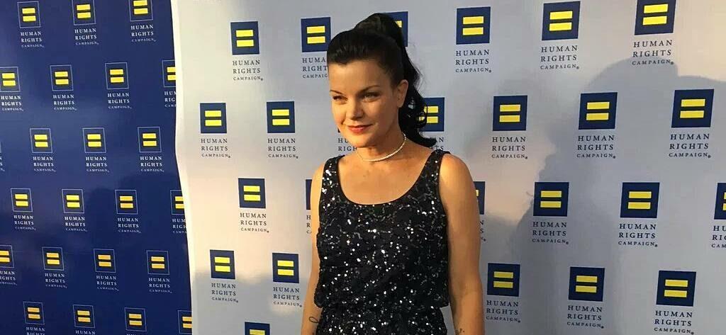 A photo showing Pauley Perrette in a black sleeveless dress