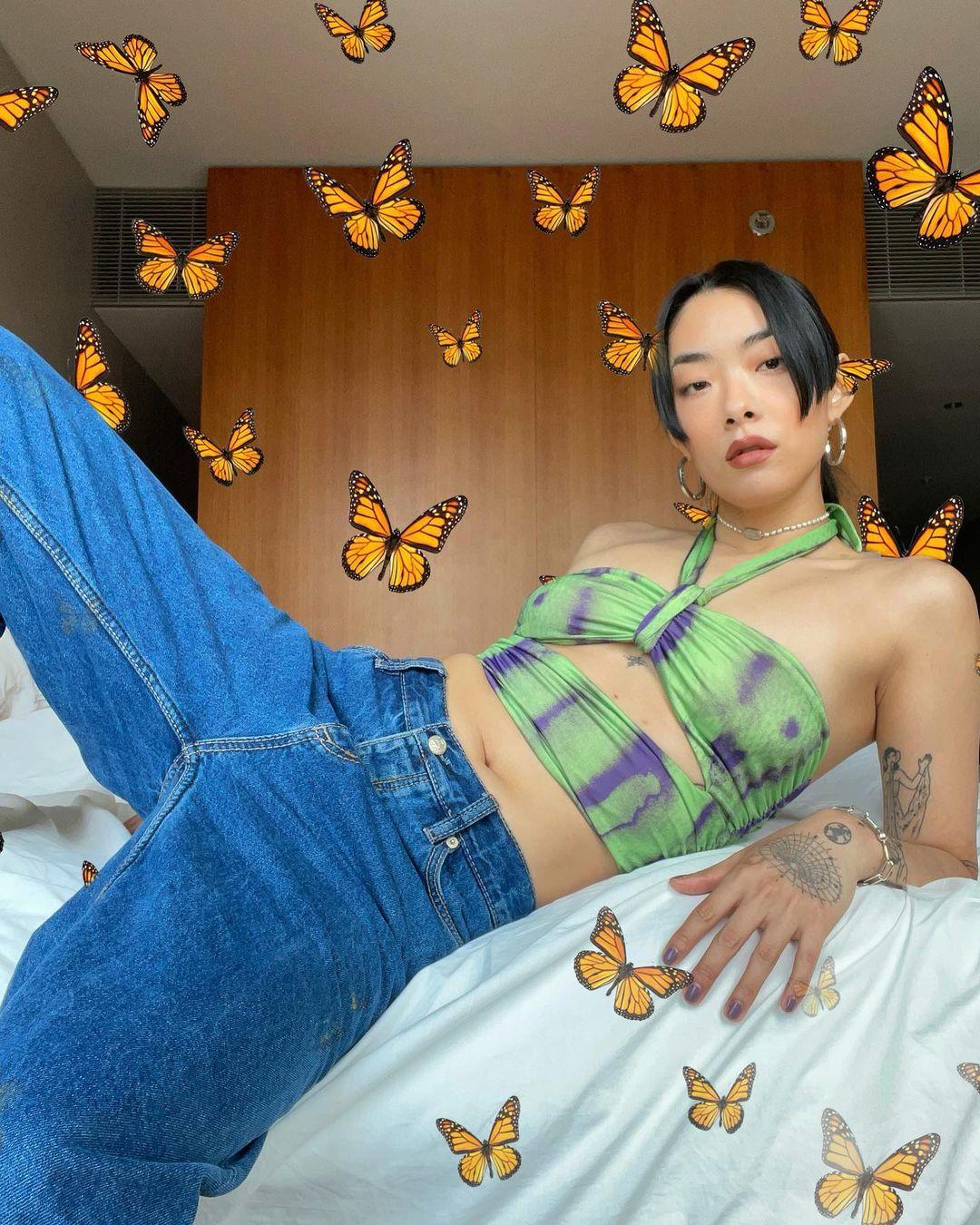 A photo showing musician, Rina Sawayama covered in butterfly prints
