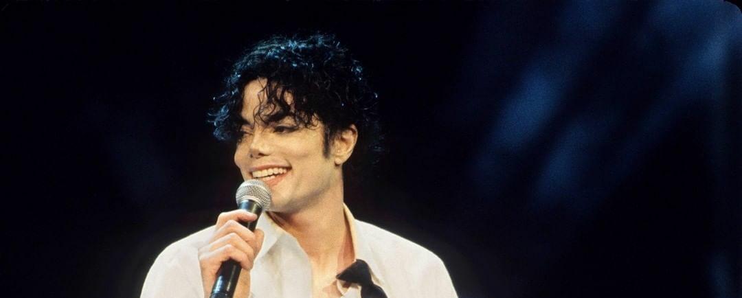 A photo showing Michael Jackson on stage in a white T-shirt.