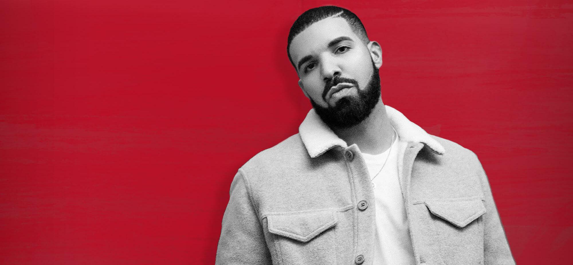 A photo showing Drake leaning against a red background.