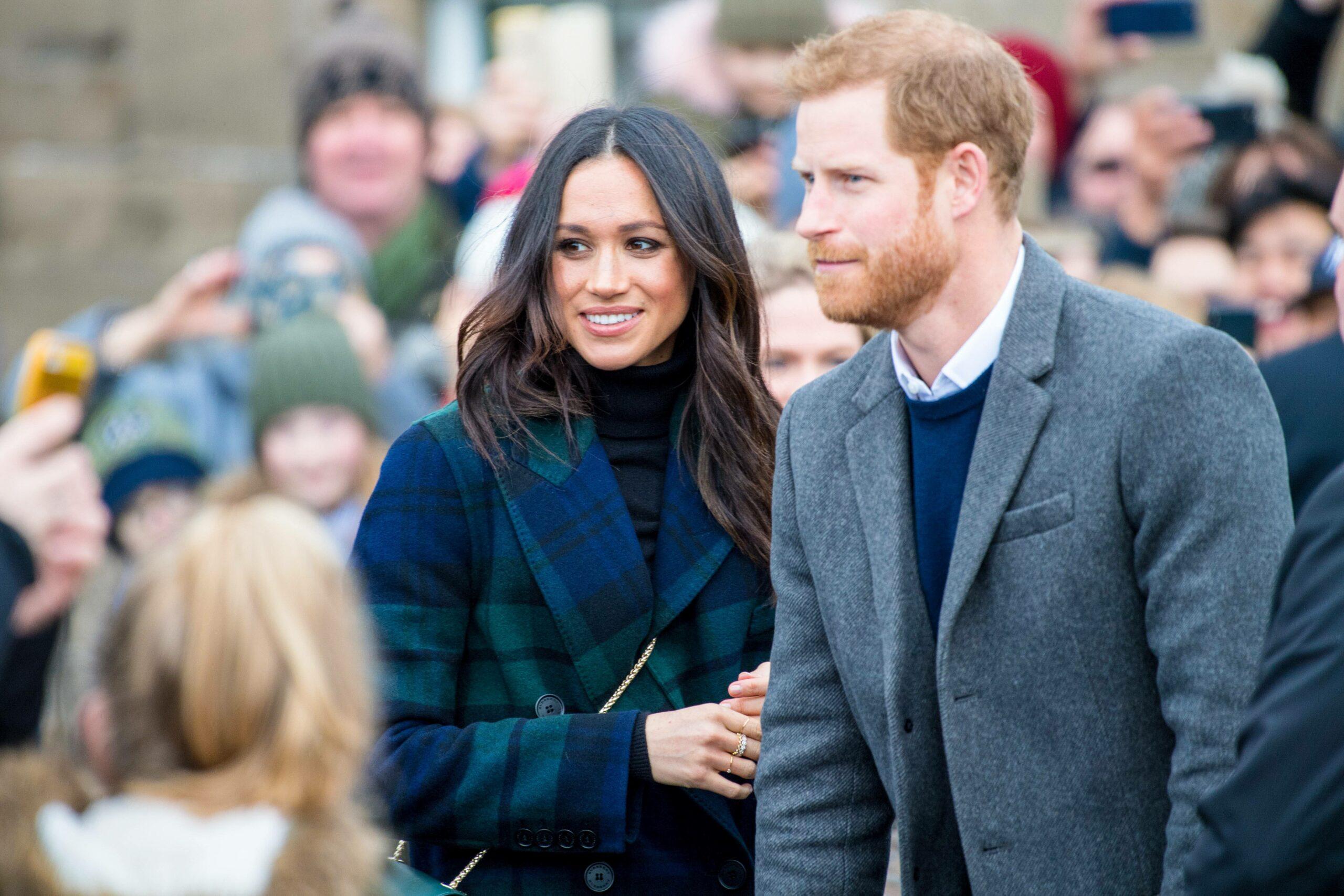 Príncipe Harry e Meghan Markle conversando com fãs