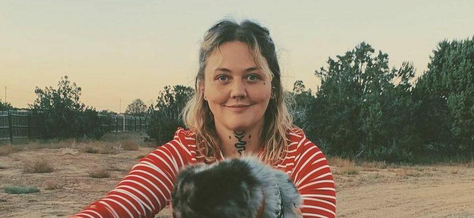 A photo showing Elle King on motorcycle ride with her furry friend