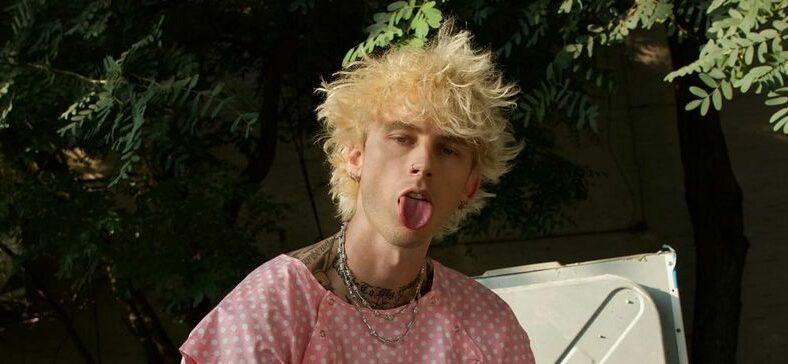 A photo showing Machine Gun Kelly in a pink color outfit.