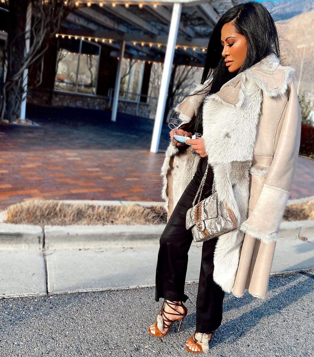 A photo of Jen Shah in fur coat paired with black pant and sandals.