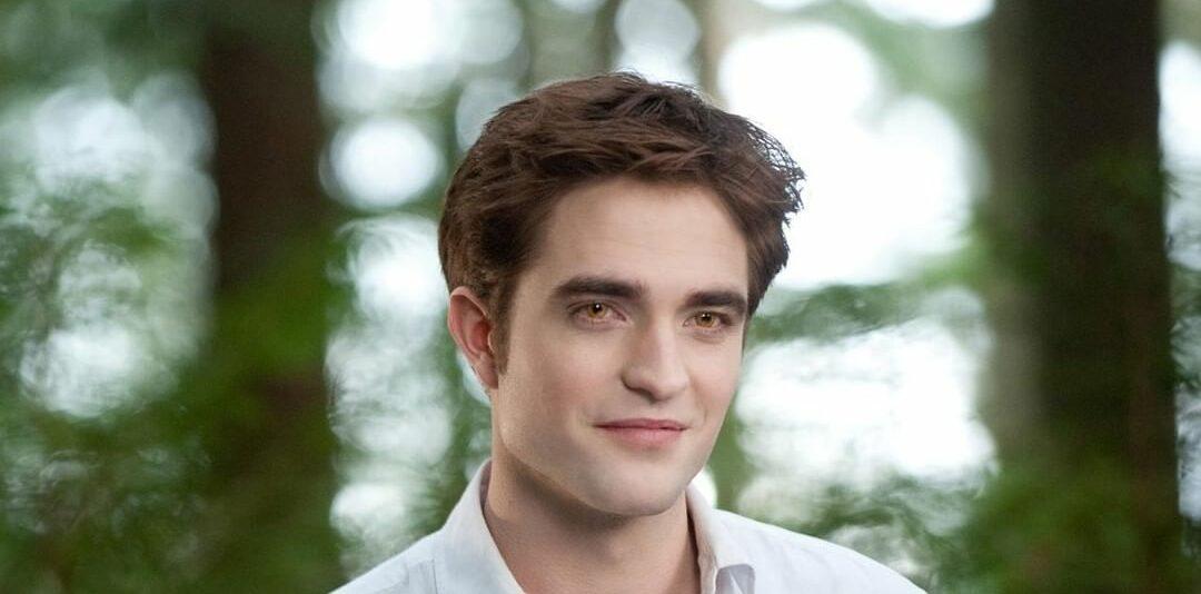 A photo showing Robert Pattinson smiling at the camera.