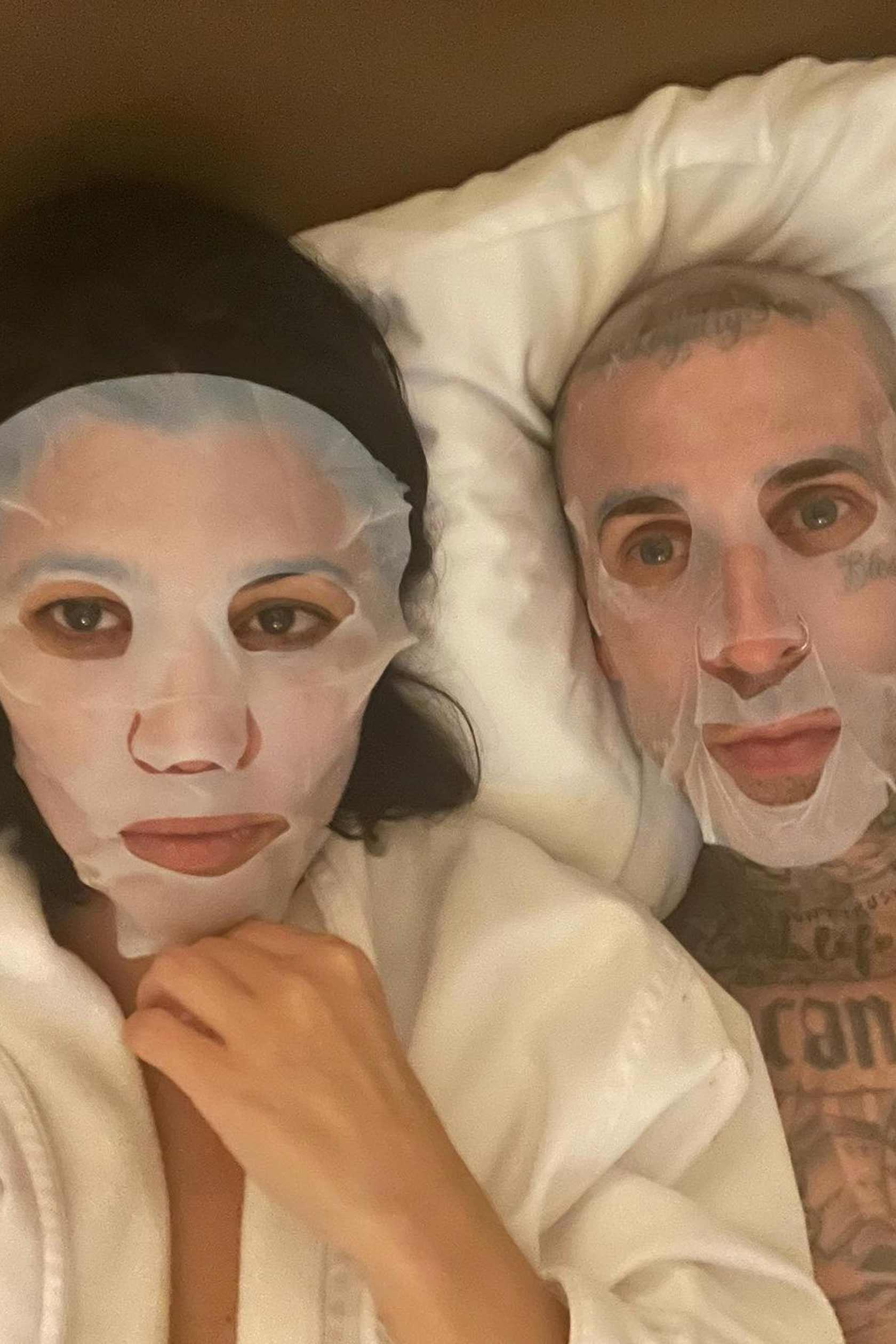 Kourtney Kardashian and Travis Barker wearing face masks