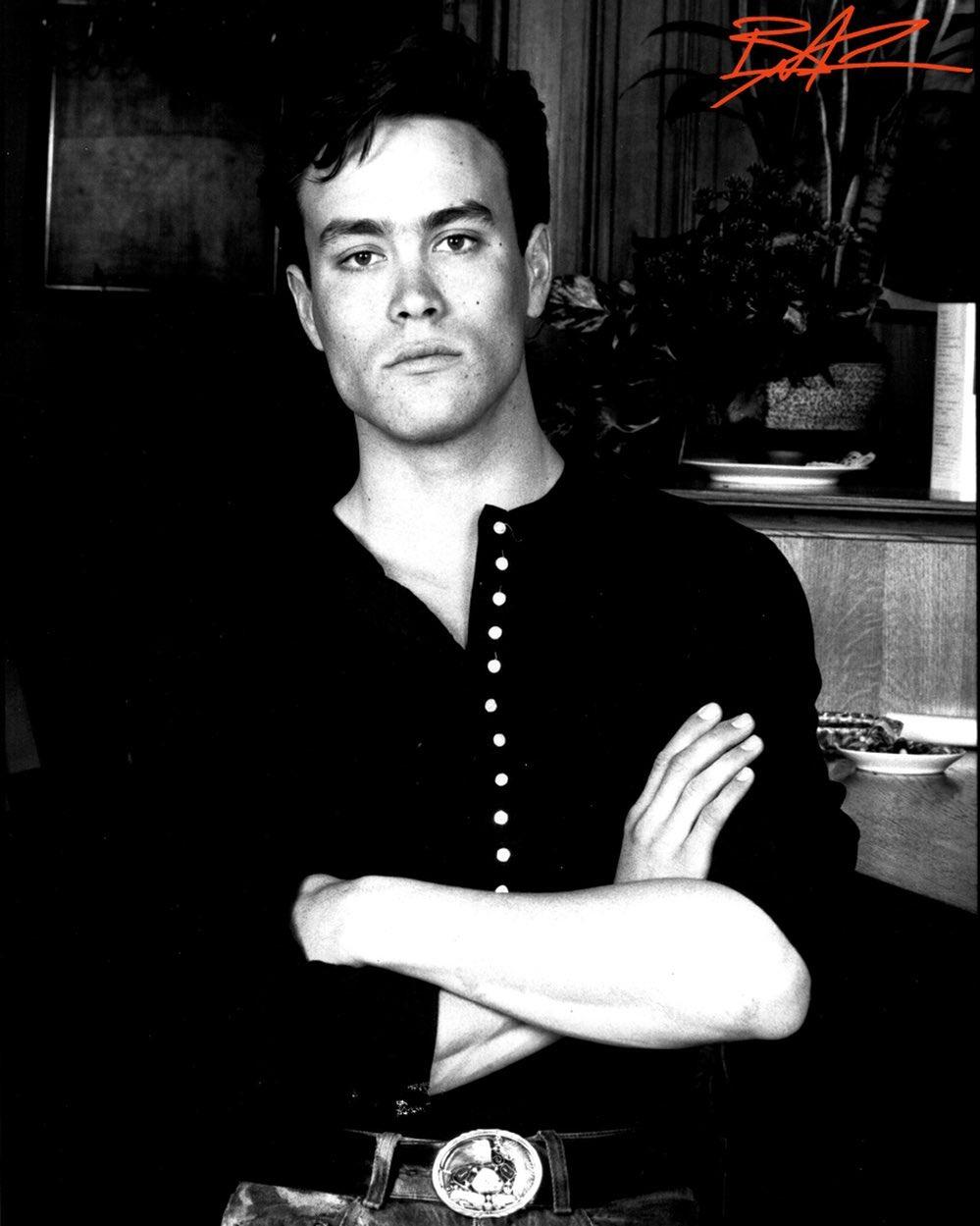 A black and white themed photo of Brandon Lee in a button-down shirt.