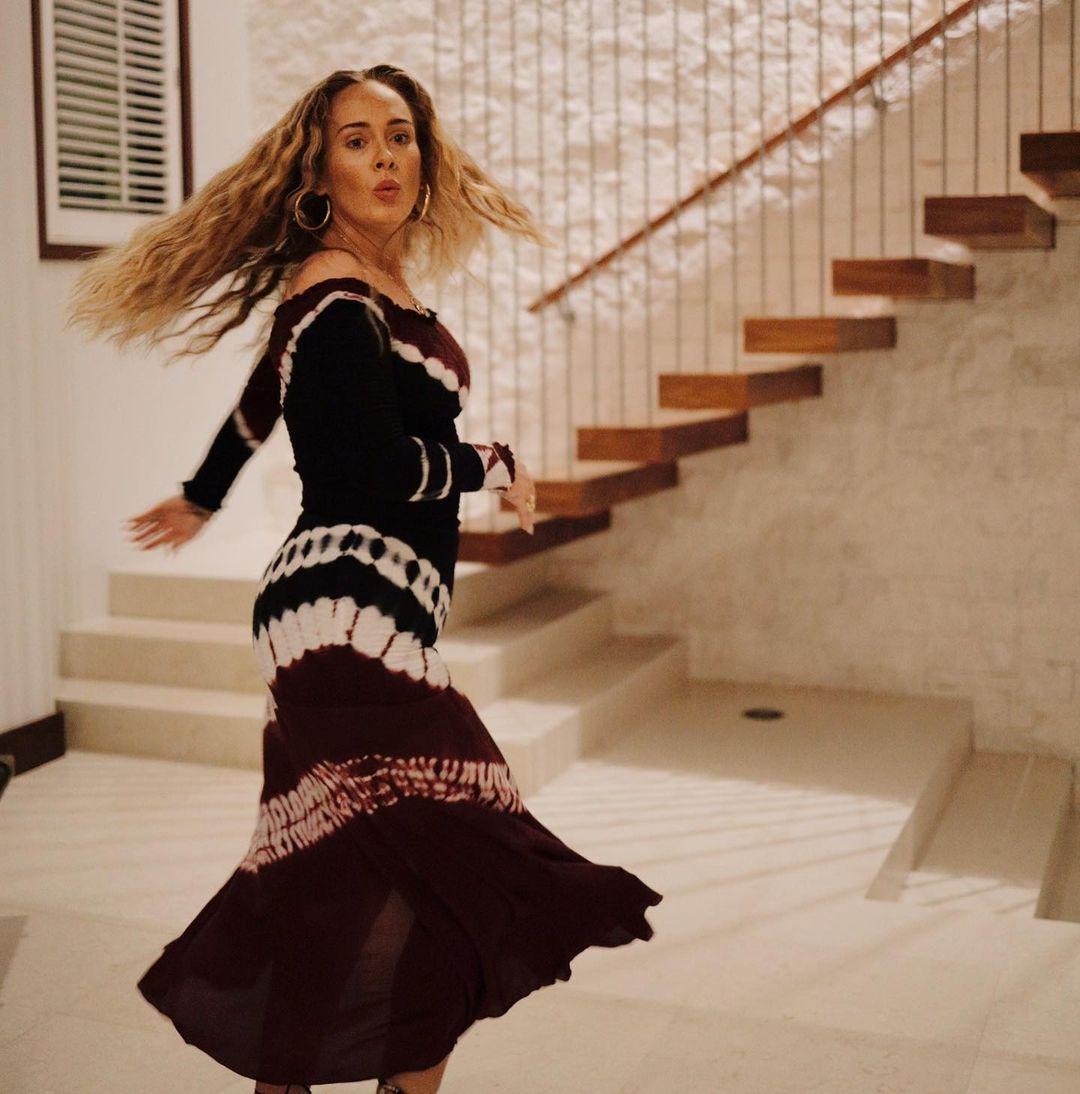Adele looks gorgeous in this photo of her dancing in a black and white design dress.