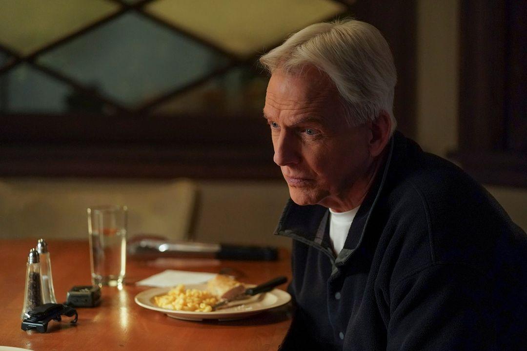 A photo showing Mark Harmon sitting in front of a table with a plate of food in front of him.