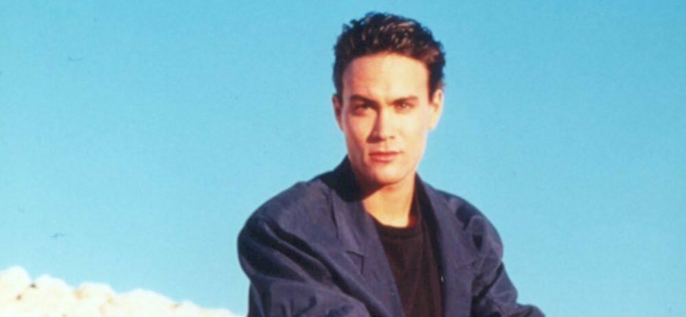 A photo showing Brandon Lee sitting on a rock.
