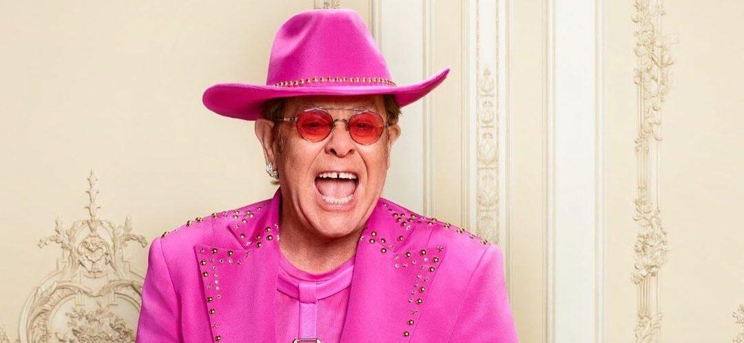 A photo showing Elton John in a pink suit and cowboy hat.