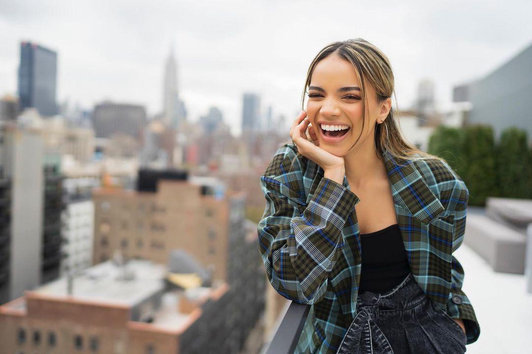 A photo showing Leslie Grace in a striped T-shirt with a huge smile on her face.