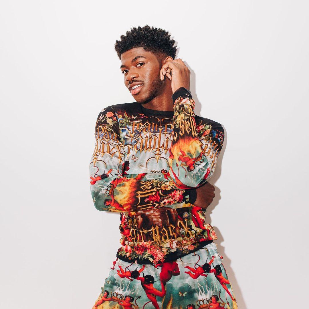 A photo showing Lil Nas X in a multicolored two-piece outfit.