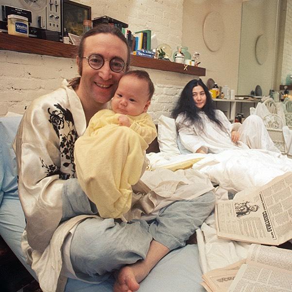 A throwback photo showing John Lennon holding his baby, and his wife, Yoko Ono, is sitting at the far end.