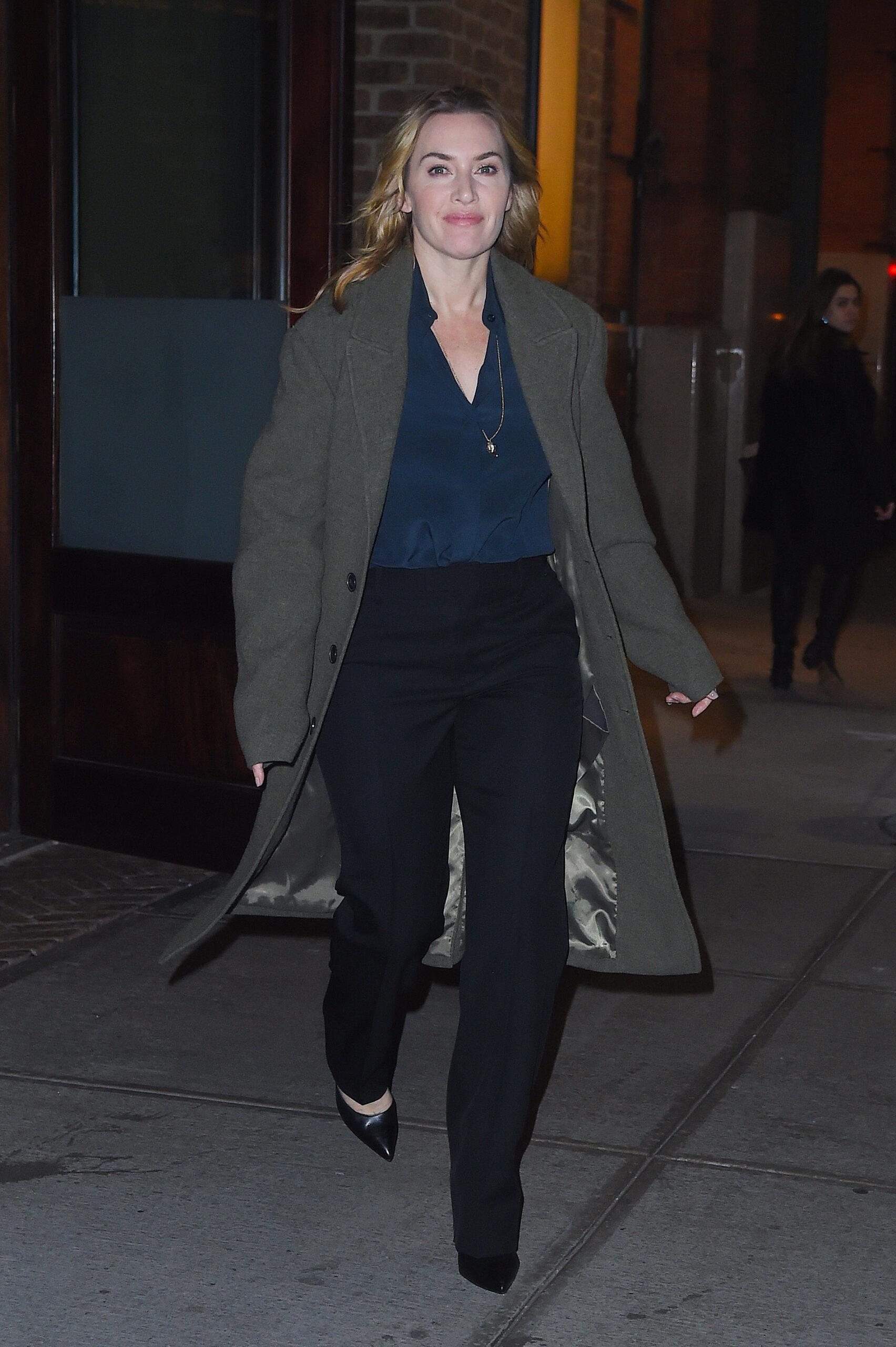 Kate Winslet heads out in a long trench coat