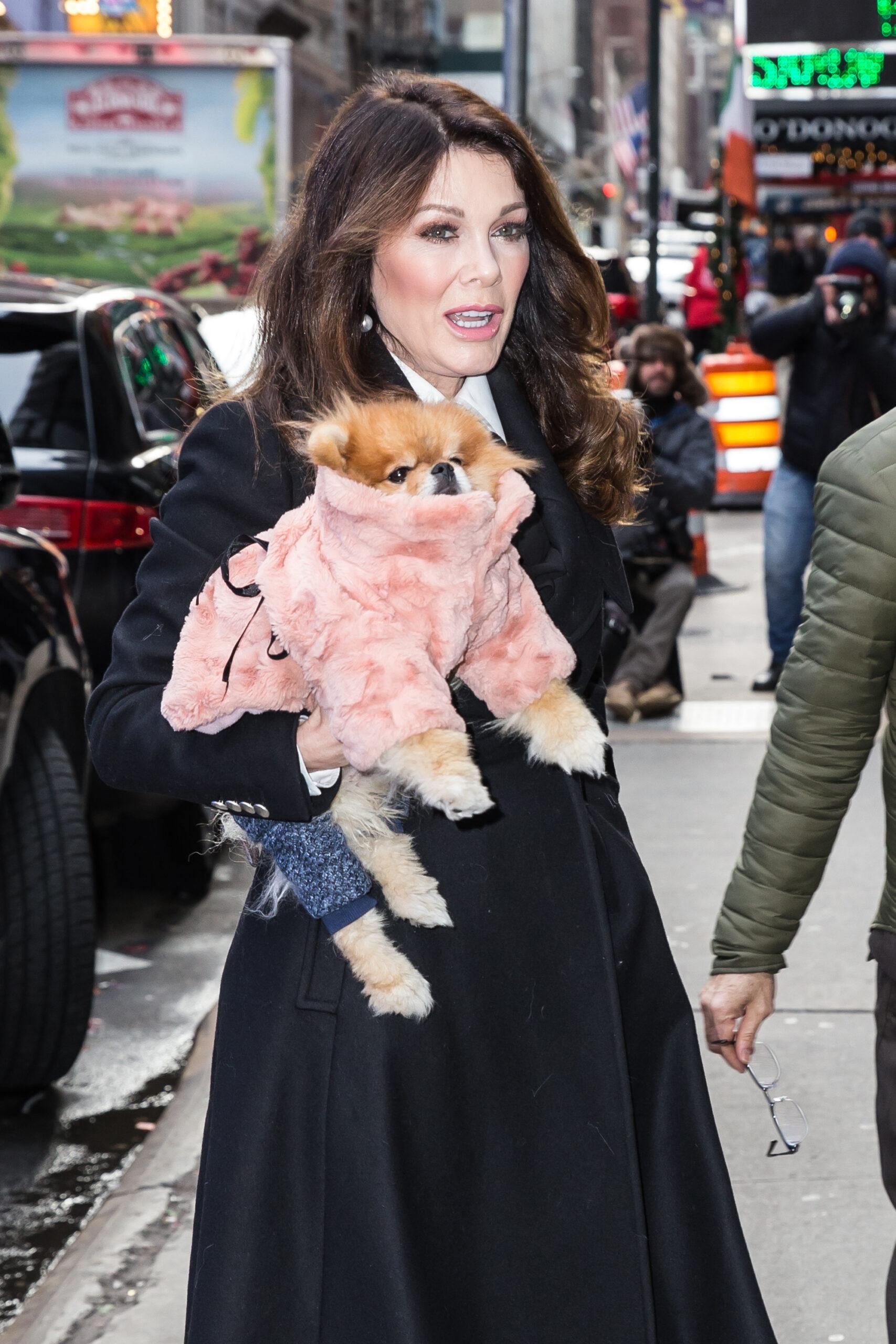 A photo of Lisa Vanderpump walking on the streets with her fully-clothed furry friend.