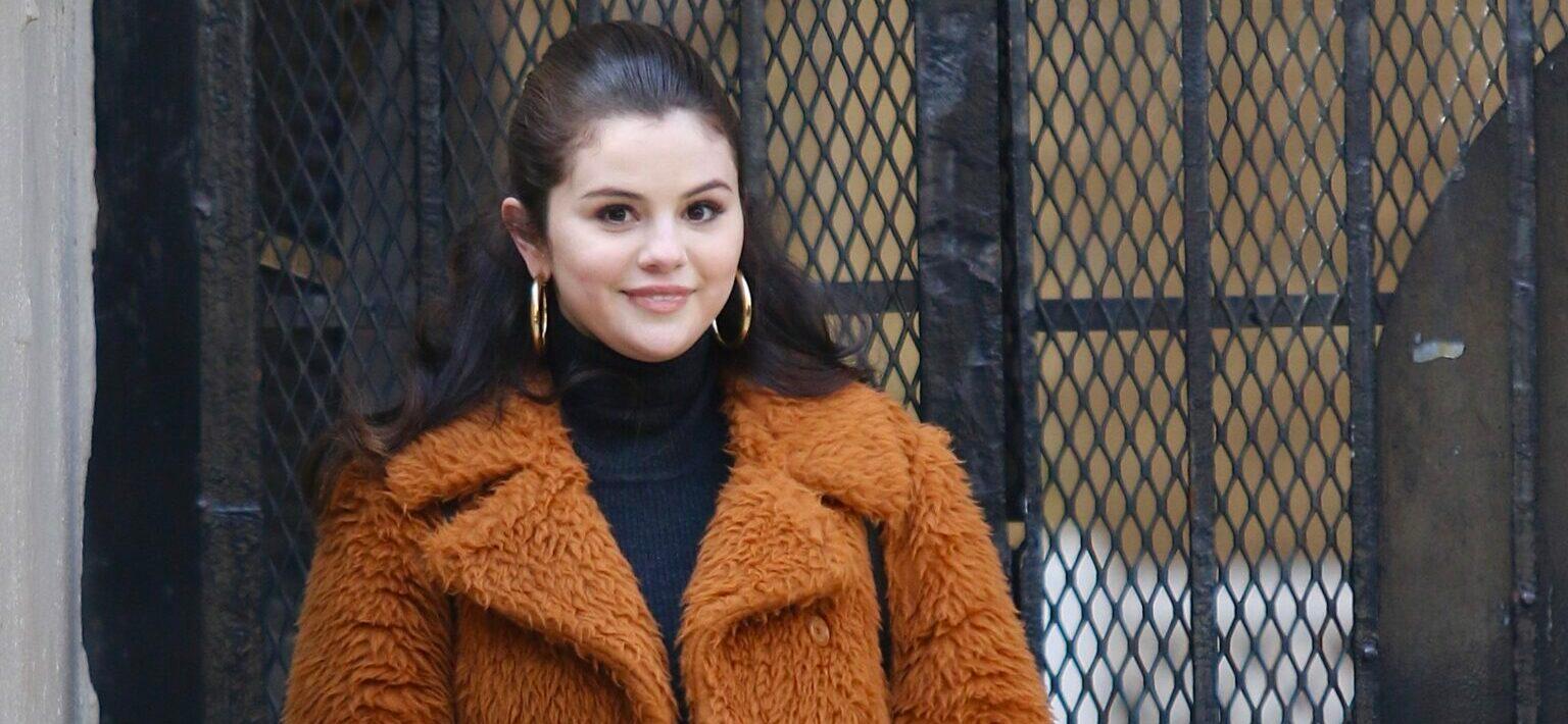 Selena Gomez is all smiles sporting a long brown/orange furry coat