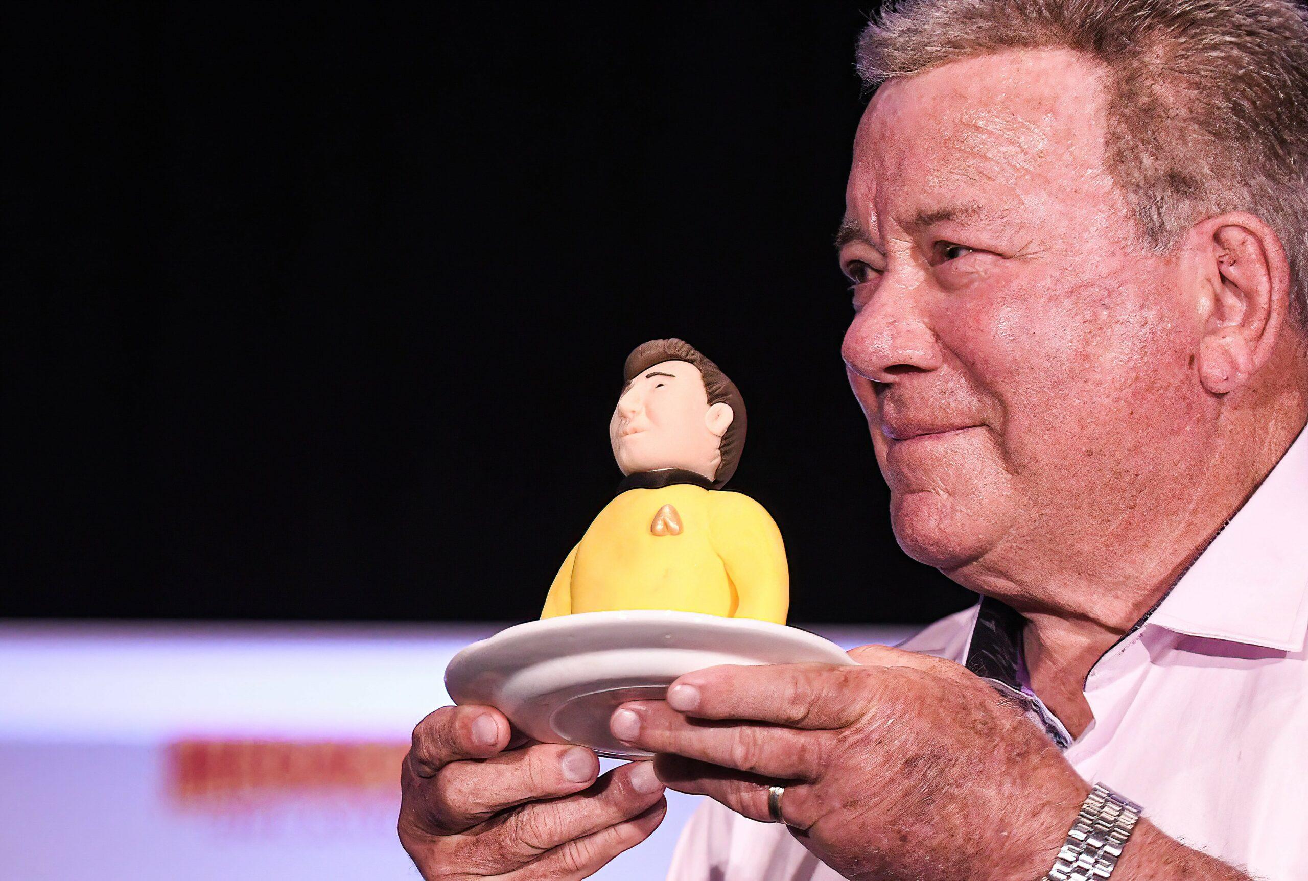 William Shatner holds a portion of a birthday cake presented to him at a Q