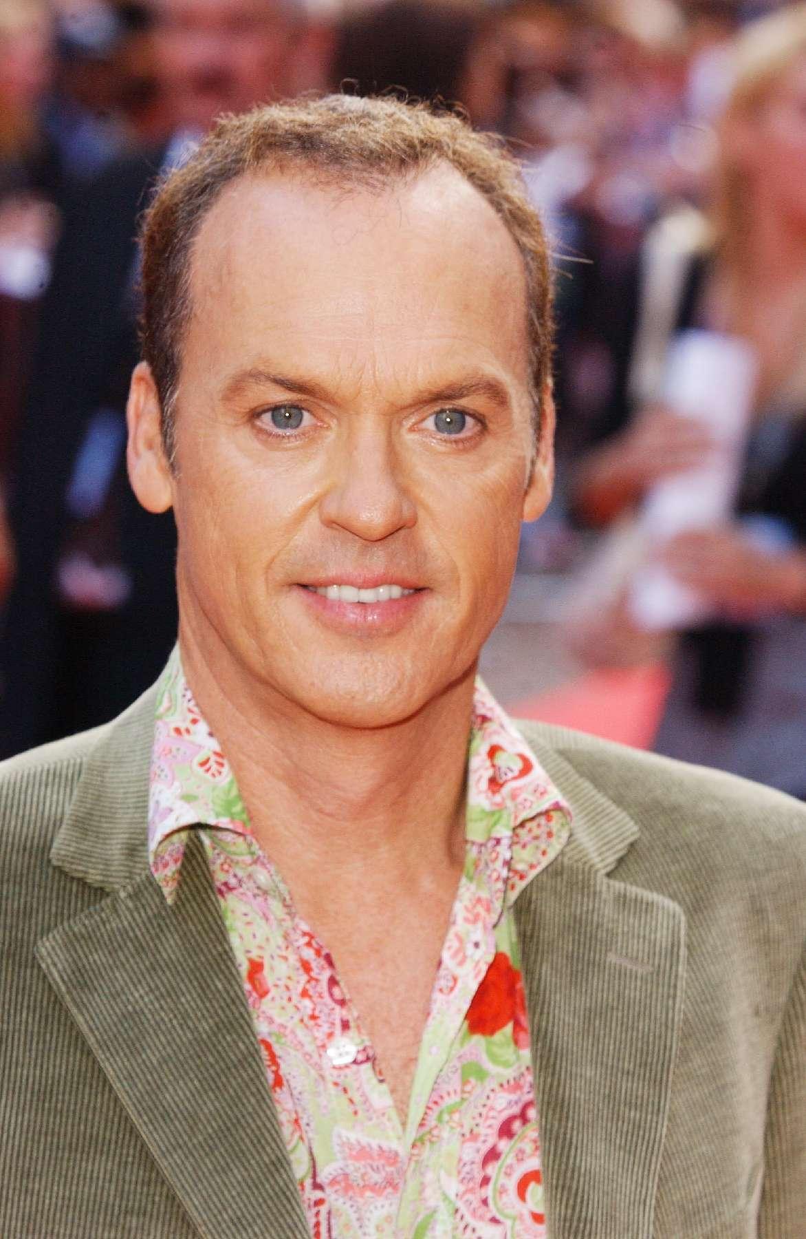 A photo showing Michael Keaton in a green suit and multicolored T-shirt.