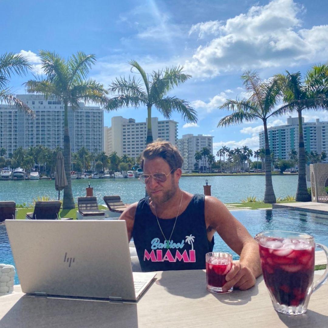 A photo of Dave Portnoy working on his laptop while having a drink.