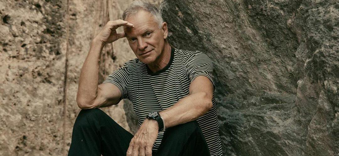 A photo showing Sting sitting on a huge rock.