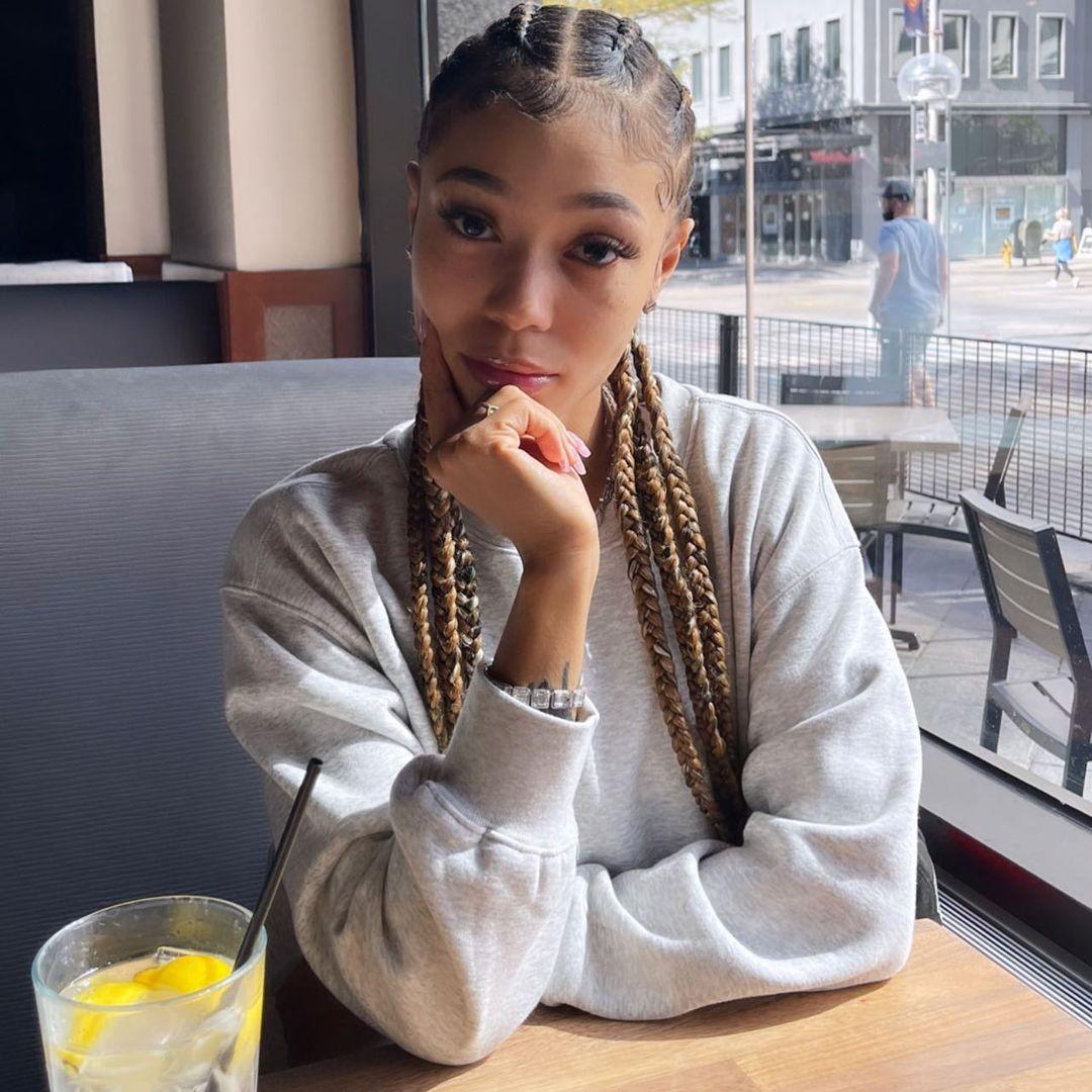 A photo showing Coi Leray at a restaurant having a drink.