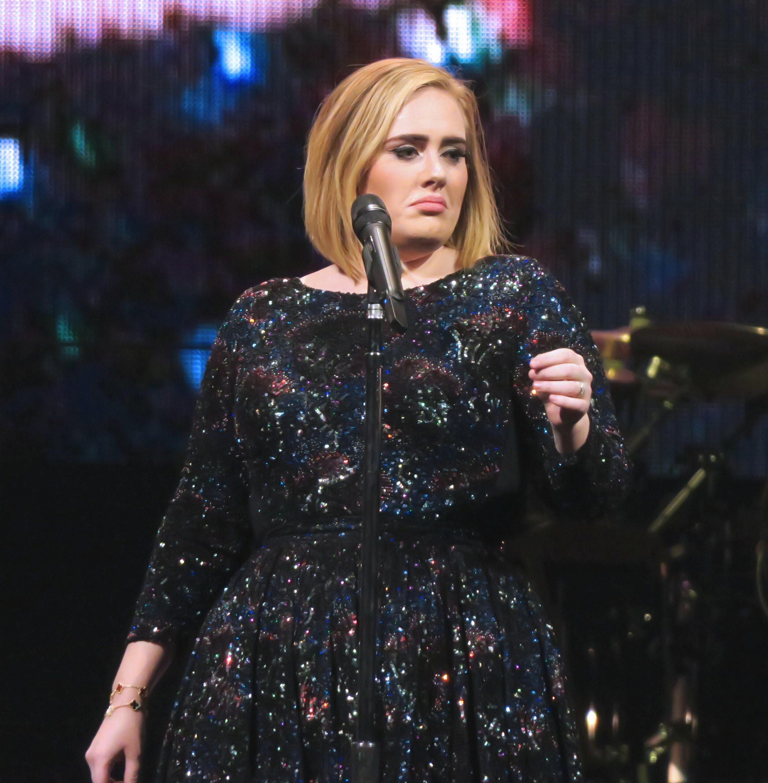Adele standing on stage.