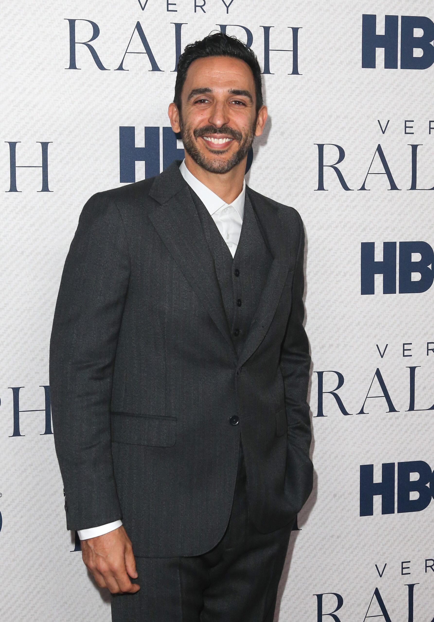 Amir Arison in a gray suit at HBO's 'Very Ralph' World Premiere