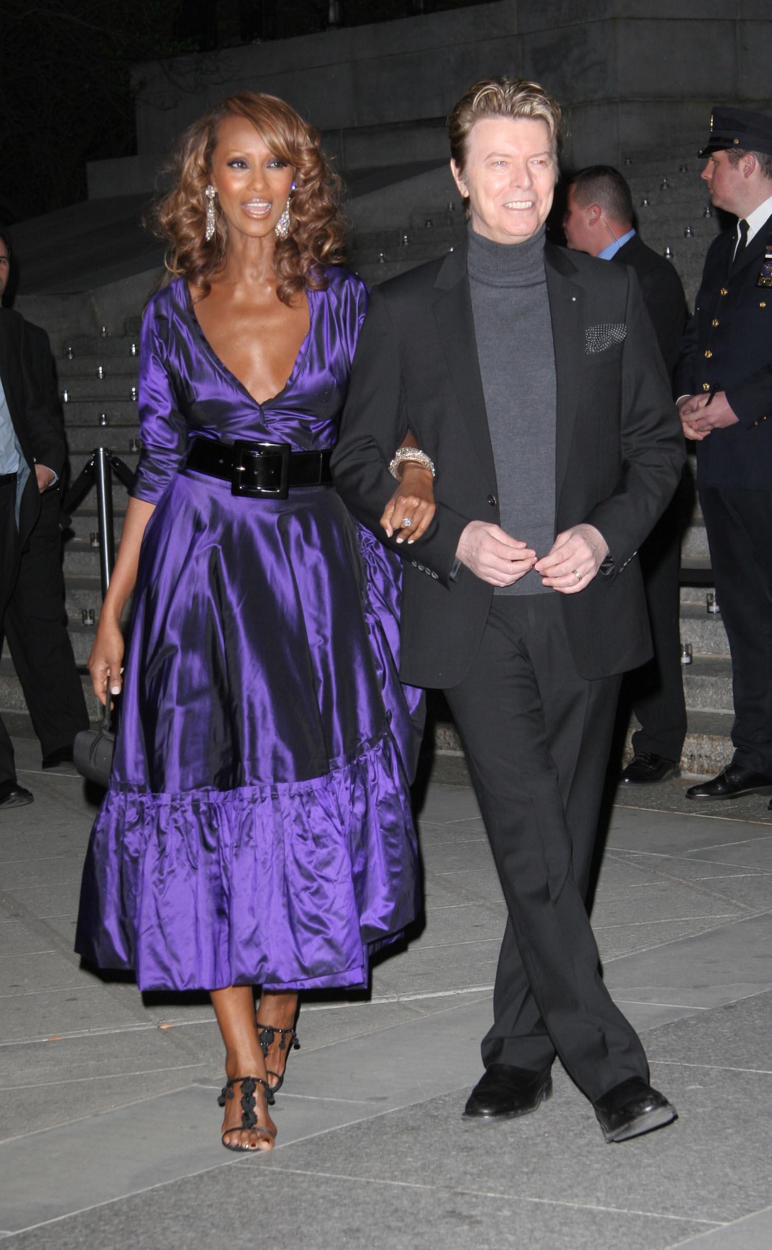 Iman and David Bowie walking together.