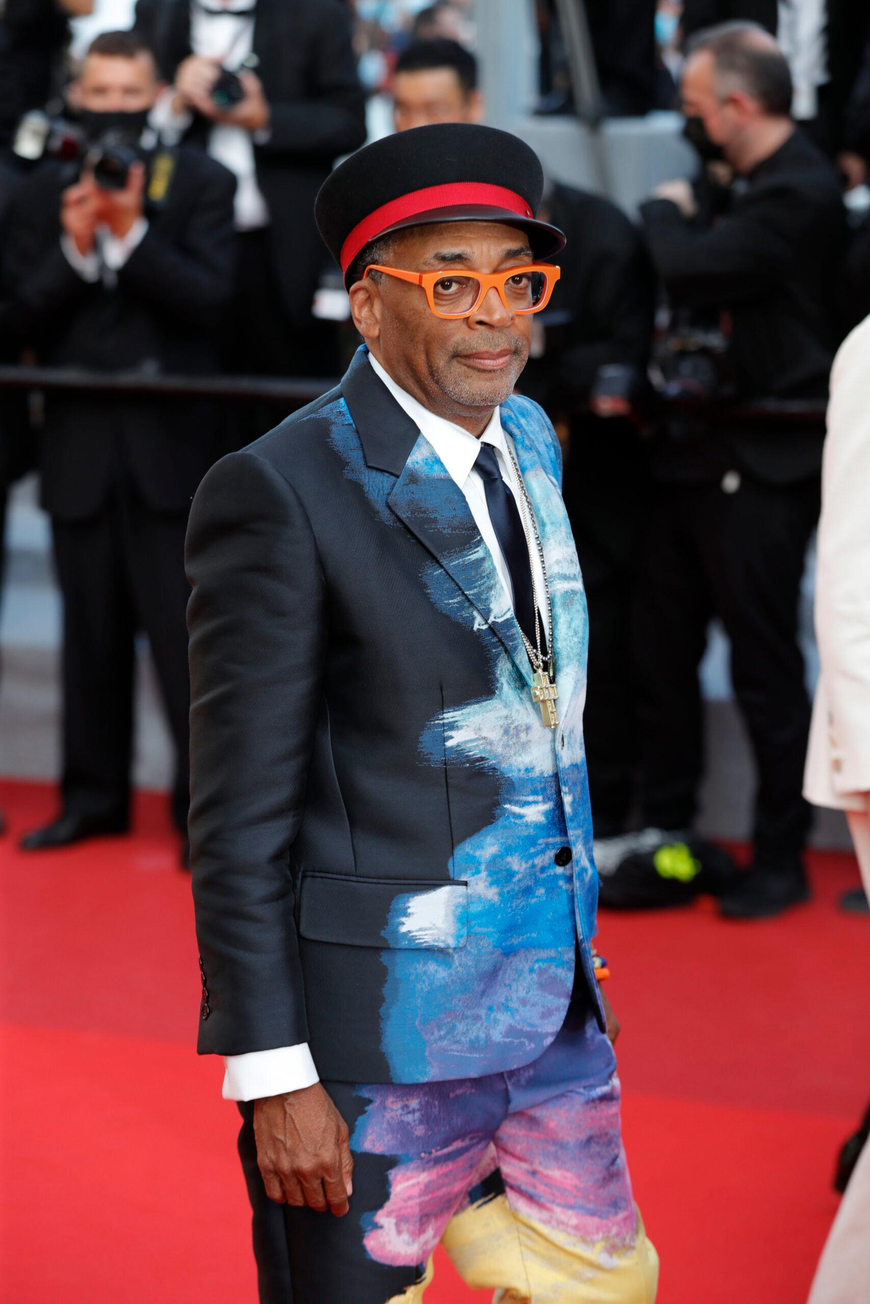 A photo showing Spike Lee at a red-carpet event, sporting a dark blue suit.