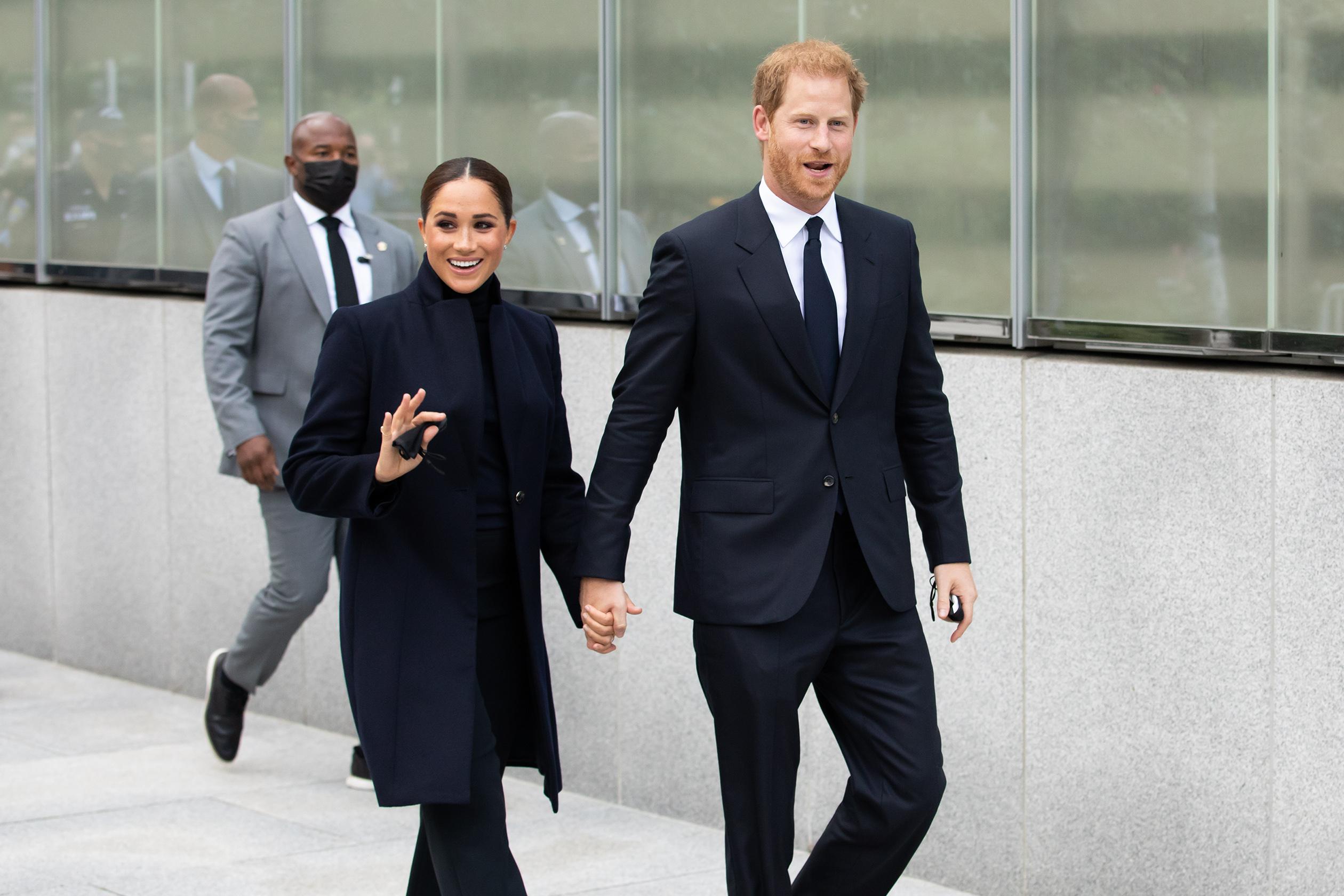 Príncipe Harry e Meghan Markle caminhando e sorrindo
