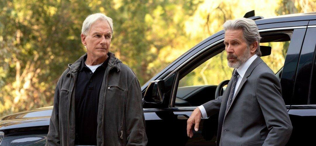 A photo showing Mark Harmon and his colleague standing by a vehicle.