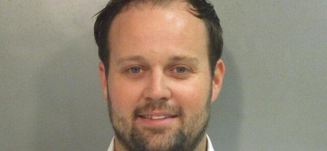 Reality star Josh Duggar smiles in this new mugshot photograph after being found guilty today