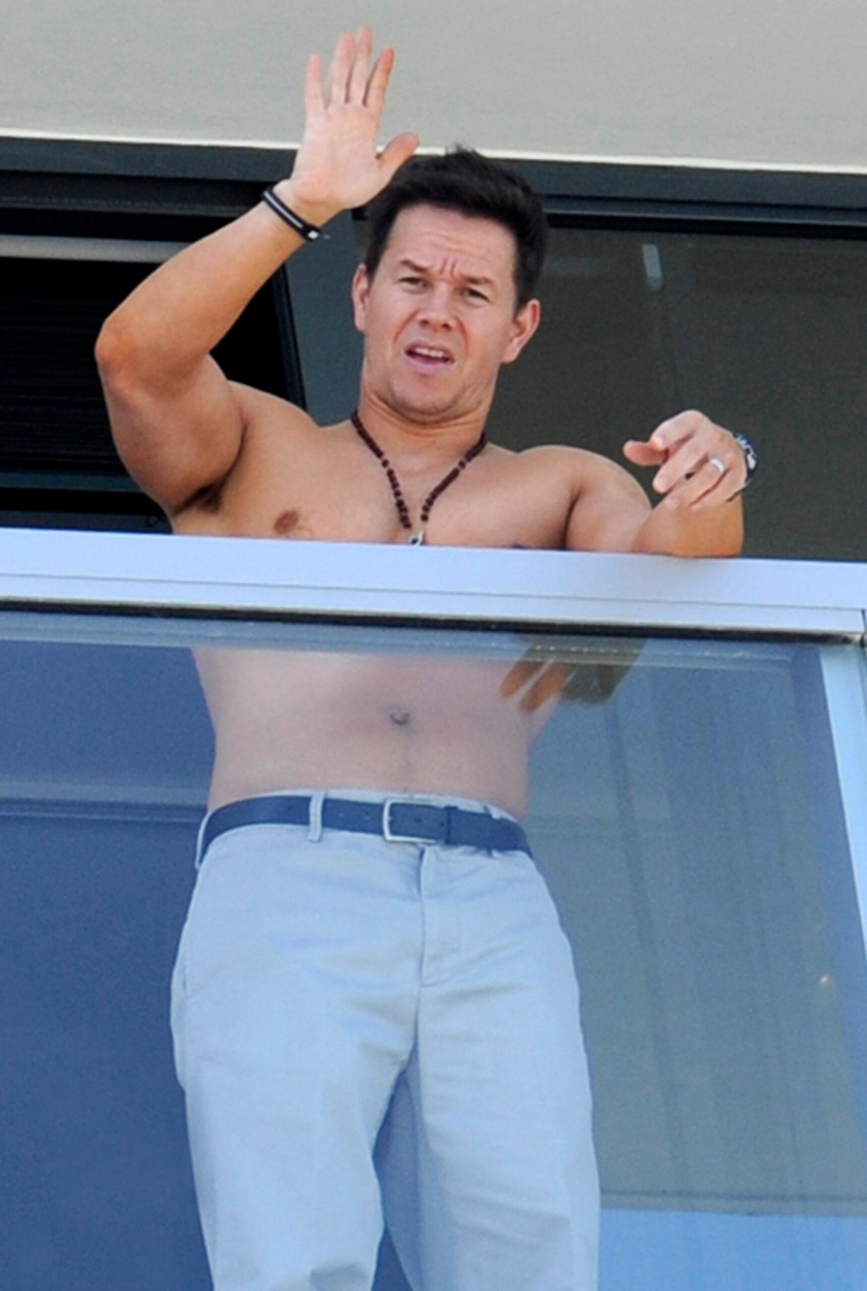 Mark Wahlberg shows off his muscles while waving shirtless from his South Beach hotel balcony