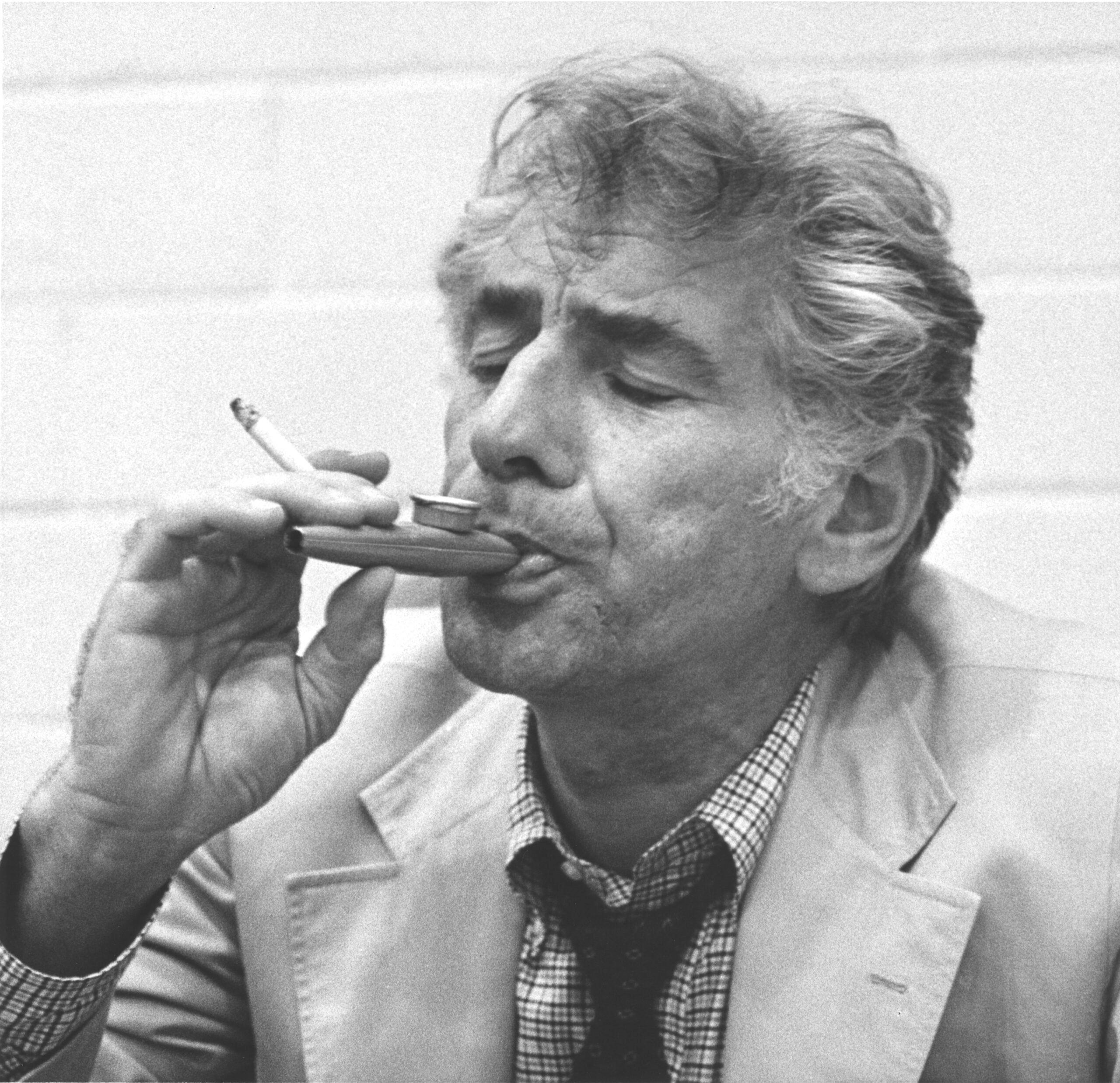 With a cigarette in his hand, conductor-composer Leonard Bernstein still manages to play a kazoo during a rehearsal of his "Mass" at the John F. Kennedy Center for the Performing Arts in Washington on September 2, 1971.