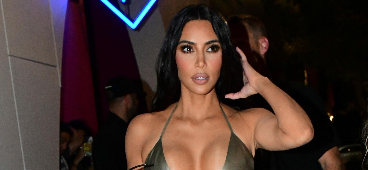 Kim Kardashian wears a silver latex bikini top with matching leggings as she and sister Khloe Kardashian arrive to her Skims pop-up event in Miami