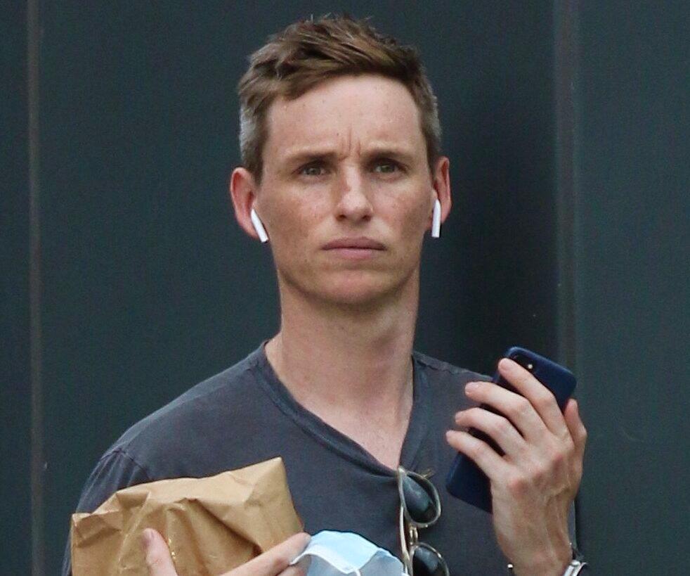 Eddie Redmayne is busy on the phone on a street corner while shopping in NYC