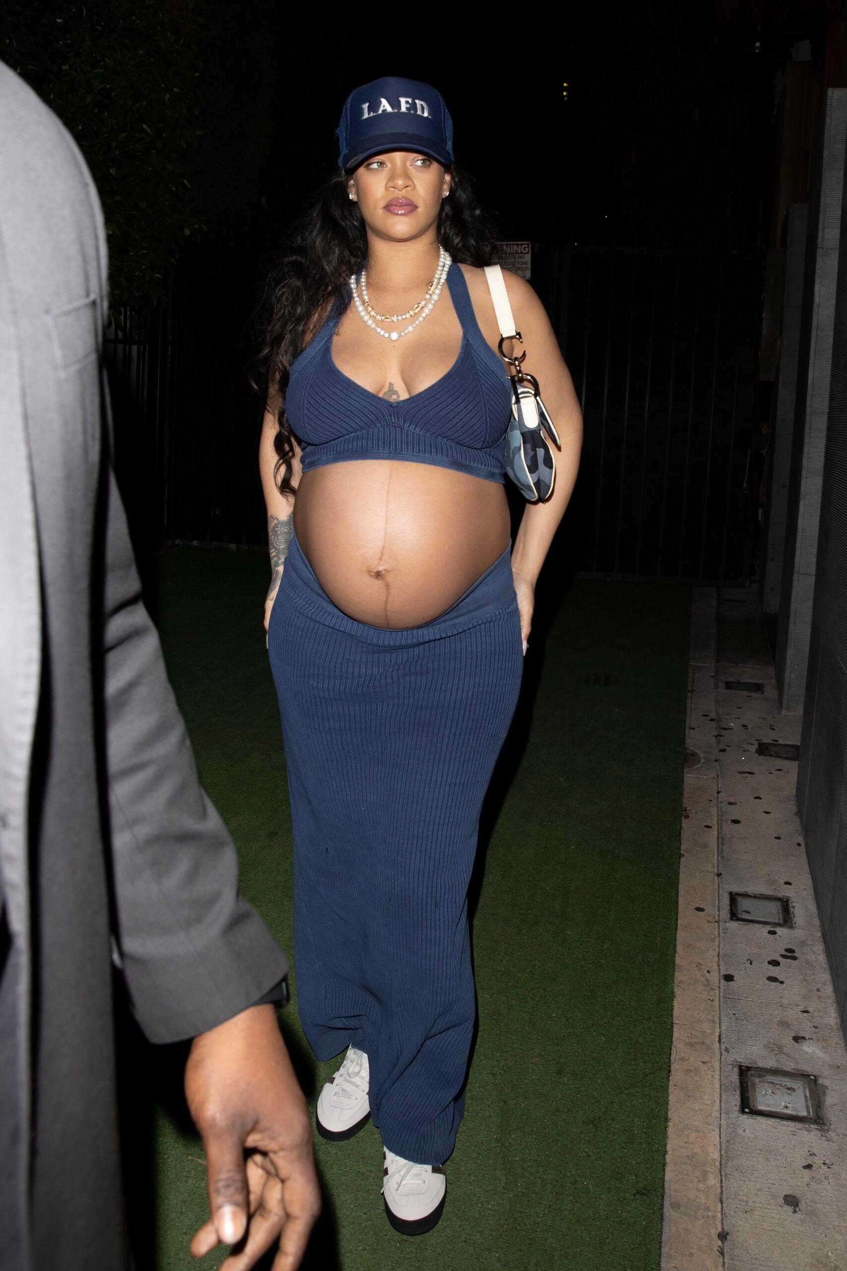 Rihanna shows off her huge baby bump while wearing denim and an LAFD hat at Nobu in West Hollywood