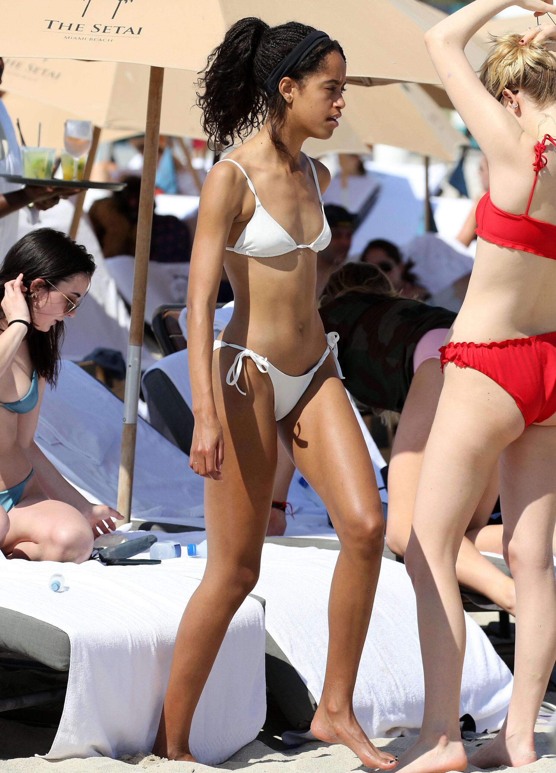 Malia Obama wears a white bikini as she relaxes with friends on the beach in Miami. 16 Feb 2019 Pictured: Malia Obama. Photo credit: MEGA TheMegaAgency.com +1 888 505 6342 (Mega Agency TagID: MEGA361385_001.jpg) [Photo via Mega Agency]