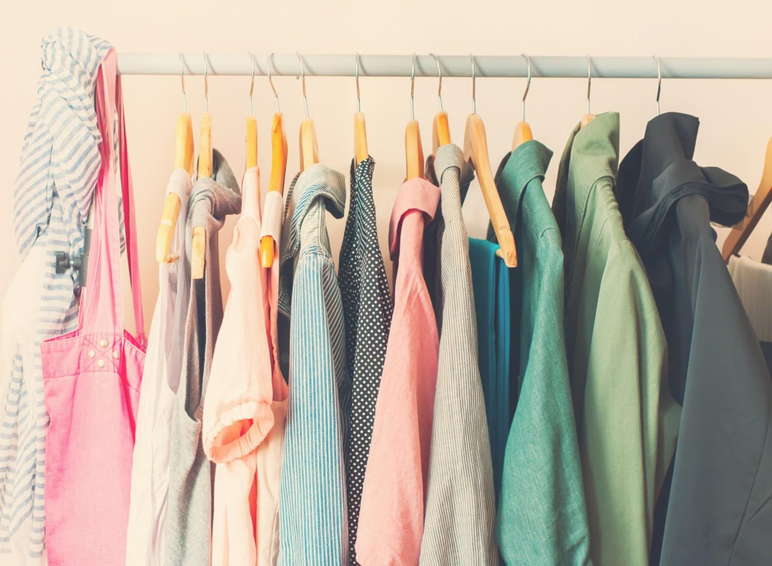 Women's summer clothes hanging in a closet.