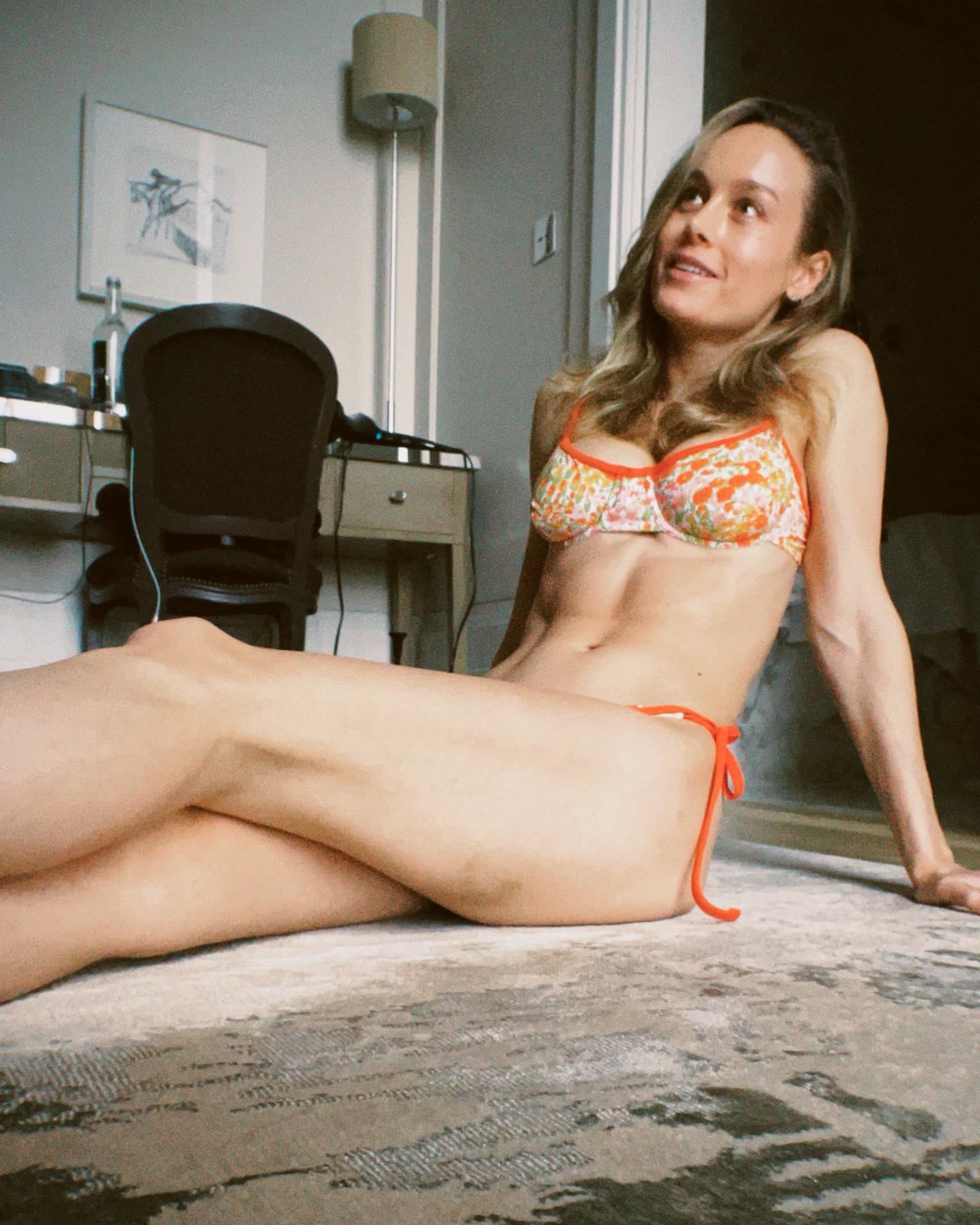Brie Larson sitting on the floor in her bikini.