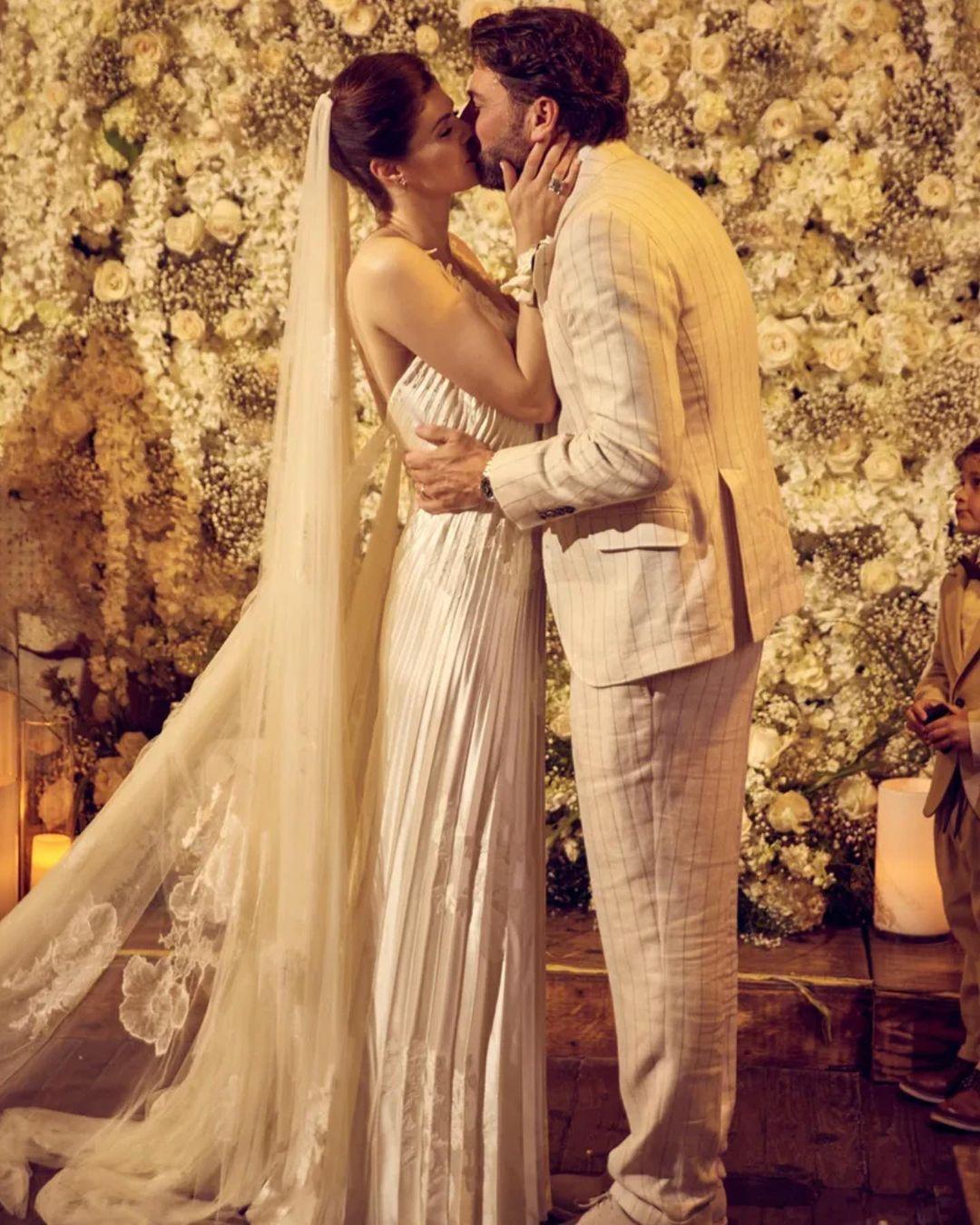 Alexandra Daddario and Andrew Form kiss at their wedding.