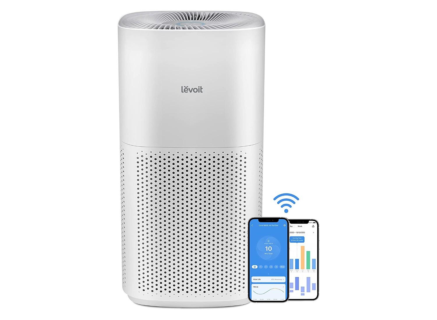 A Levoit air purifier and a phone on a white background.