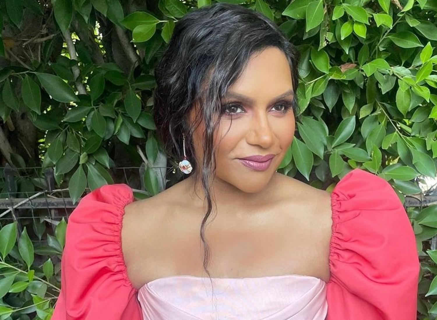 Mindy Kaling in front of a tree.